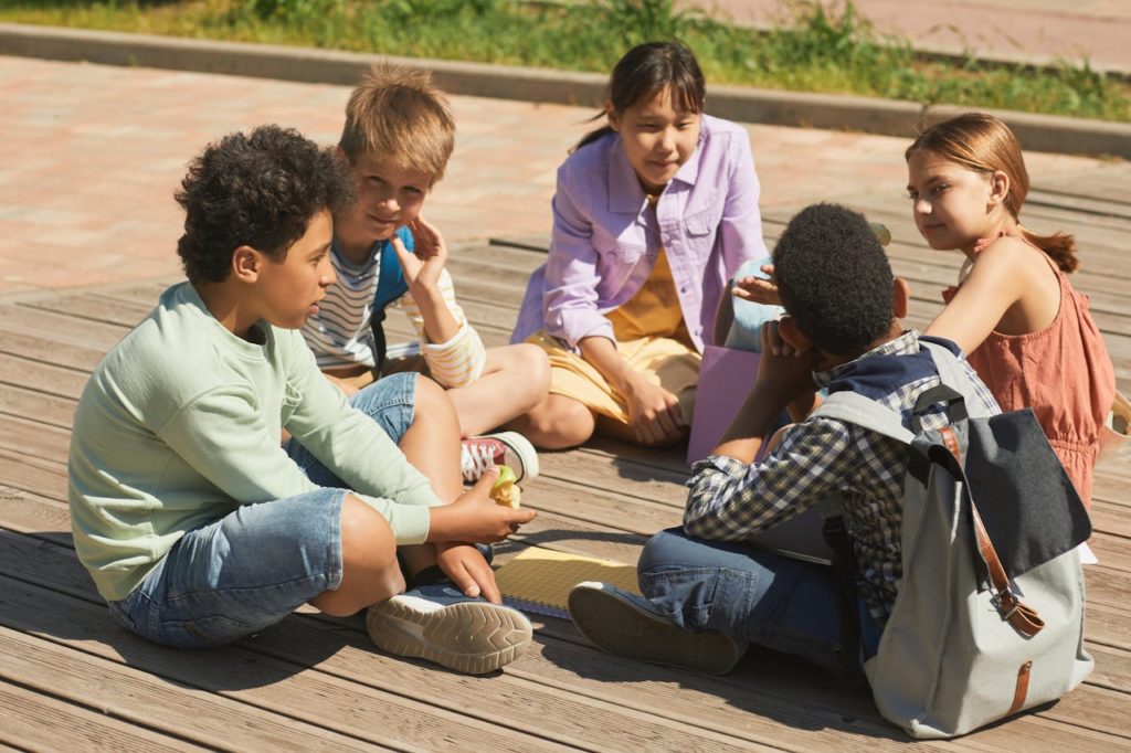 Group of Schoolkids Sitting Outside during a Lunch Break